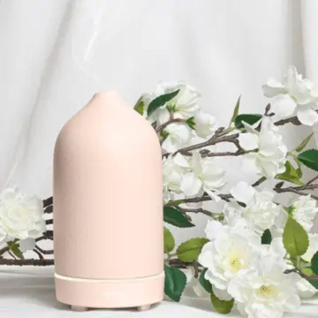 Umbra Pink Ceramic Diffuser next to flowers